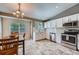 Bright kitchen featuring stainless steel appliances, tile backsplash, and an adjacent dining area at 5534 S Wenatchee St, Aurora, CO 80015