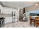 A well-designed kitchen open to the staircase offers modern appliances and bright, white cabinets at 5534 S Wenatchee St, Aurora, CO 80015