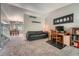 Comfortable living room with carpeted floors, a gray sofa, a desk, and an adjacent dining area at 5534 S Wenatchee St, Aurora, CO 80015