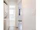 Hallway leading to a bathroom with patterned tile flooring and a glimpse into the adjacent room at 1476 W Dakota Ave, Denver, CO 80223