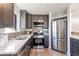 Sleek kitchen with stainless steel appliances, quartz countertops, and modern tile backsplash at 1476 W Dakota Ave, Denver, CO 80223