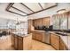 Well-lit kitchen with wood cabinets, stainless steel appliances, and a central island cooktop at 6726 Taft Cir, Arvada, CO 80004