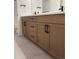 Bathroom vanity with and sinks, black hardware, and stone tile flooring at 5621 W 141St Ln, Broomfield, CO 80020