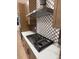Stylish stainless steel stovetop with white countertops, custom cabinetry, and decorative tile backsplash at 5621 W 141St Ln, Broomfield, CO 80020