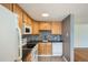 Kitchen featuring tiled floors, wood cabinets, black counters and backsplash, with white appliances at 1182 N Clermont St # 101, Denver, CO 80220