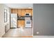 Bright kitchen featuring tiled floors, wood cabinets, and white appliances at 1182 N Clermont St # 101, Denver, CO 80220
