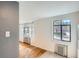 Sunlit living room with hardwood floors, black framed windows and radiator heating at 1182 N Clermont St # 101, Denver, CO 80220