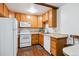 Bright kitchen with wood cabinets, white appliances, and a light countertop at 9385 E Center Ave # 1D, Denver, CO 80247