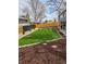 Lush backyard featuring manicured lawn, designated fire pit, and a cornhole setup at 12555 W 61St Ave, Arvada, CO 80004