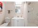 Clean and modern bathroom with a white vanity, a well-lit mirror, and a shower with a sleek marble tile surround at 12555 W 61St Ave, Arvada, CO 80004