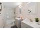 Bright bathroom featuring dual vanities, modern fixtures and a shower tub combo at 12555 W 61St Ave, Arvada, CO 80004