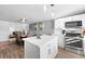 Bright kitchen featuring white cabinets, stainless steel appliances, a large island, and an adjacent dining area, perfect for modern living at 12555 W 61St Ave, Arvada, CO 80004