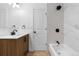 Bright bathroom featuring wood vanity, marble-look tile, and sleek black fixtures at 12635 E Pacific Cir # A, Aurora, CO 80014