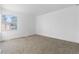 Spacious bedroom with neutral carpeting, a large window offering natural light, and white walls at 12635 E Pacific Cir # A, Aurora, CO 80014