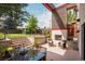 Outdoor patio with a dining area and outdoor fireplace, backing up to a large backyard at 111 S Hudson St, Denver, CO 80246