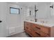 A beautifully remodeled bathroom features a double sink vanity, shower and modern tile flooring at 111 S Hudson St, Denver, CO 80246