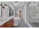 Bright bathroom showcasing a skylight, a modern soaking tub, glass-enclosed shower, and an elegant vanity with ample natural light at 111 S Hudson St, Denver, CO 80246