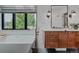 Chic bathroom featuring a soaking tub with sleek fixtures, a modern vanity, and natural light from a window at 111 S Hudson St, Denver, CO 80246