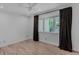 A light bedroom with wood floors, a ceiling fan, a window with curtains and fresh neutral paint at 111 S Hudson St, Denver, CO 80246