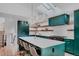 Bright kitchen with stainless steel appliances, emerald cabinetry, and an island with seating at 111 S Hudson St, Denver, CO 80246