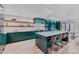 The updated kitchen features a large island, stainless steel appliances, floating shelves and modern lighting at 111 S Hudson St, Denver, CO 80246