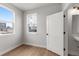 Well-lit bedroom with hardwood floors, two windows, and a white door leading to the ensuite bathroom at 14283 Currant St, Broomfield, CO 80020