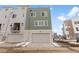 Modern townhome featuring a two-car garage, neutral siding, and a well-kept front lawn at 14283 Currant St, Broomfield, CO 80020