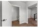 Hallway with hardwood floors and white trim leading to powder room and staircase at 14283 Currant St, Broomfield, CO 80020