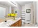 Bright bathroom with double sink vanity, tile floors, large mirror, and decorative shelving at 85 Uinta Way # 603, Denver, CO 80230