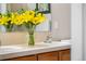 Bathroom vanity features double sinks with yellow flowers in a vase for a decorative touch at 85 Uinta Way # 603, Denver, CO 80230