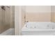 Clean bathroom with a jacuzzi tub, separate shower, and neutral tile at 85 Uinta Way # 603, Denver, CO 80230