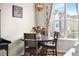Cozy dining nook with round wood table, stylish light fixture, and bright window at 85 Uinta Way # 603, Denver, CO 80230