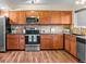Charming kitchen boasting wood cabinets, stainless steel appliances, and granite countertops at 1272 S Crystal Way, Aurora, CO 80012