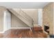 Cozy living room featuring hardwood floors, a stone fireplace, and a staircase with decorative iron railing at 1272 S Crystal Way, Aurora, CO 80012