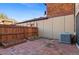 Brick patio area with wood fence, exterior of home, and air conditioner at 1272 S Crystal Way, Aurora, CO 80012
