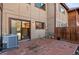 Brick patio area with wood fence, exterior of home, and sliding glass door at 1272 S Crystal Way, Aurora, CO 80012