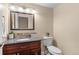 Well-lit half bathroom with a vanity, mirror, and a toilet at 1272 S Crystal Way, Aurora, CO 80012