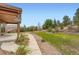 The backyard has mature trees, walkway, landscaping and a grassy area at 23993 E Briarwood Dr, Aurora, CO 80016