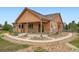 Exterior view of a single-story home with stone accents, covered porch, and gravel landscaping at 23993 E Briarwood Dr, Aurora, CO 80016