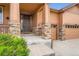 Inviting covered front porch with stone accents and wood railing, leading to a paneled front door at 23993 E Briarwood Dr, Aurora, CO 80016