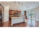 Gourmet kitchen features a central island, stainless steel appliances, and custom wood cabinetry at 23993 E Briarwood Dr, Aurora, CO 80016