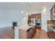 Gourmet kitchen with an island, stainless steel appliances, granite countertops, and wood cabinetry at 23993 E Briarwood Dr, Aurora, CO 80016