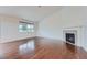 Bright living room boasts vaulted ceilings, a cozy fireplace, and gleaming hardwood floors at 23993 E Briarwood Dr, Aurora, CO 80016