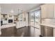 Open kitchen with stainless appliances, white cabinets, and a sliding glass door at 7397 Red Fox Way, Littleton, CO 80125