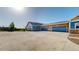Spacious driveway with ample parking, complemented by stone accents and blue garage doors at 12604 Madison Way, Thornton, CO 80241