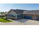 Exterior view of a blue and brown home with a large driveway leading to a multi-car garage at 12604 Madison Way, Thornton, CO 80241
