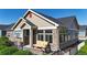 Charming home featuring stone accents, manicured lawn, and a cozy front porch sitting area at 12604 Madison Way, Thornton, CO 80241