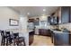 Modern kitchen features stainless appliances, dark wood cabinetry, and granite countertops with seating at 12604 Madison Way, Thornton, CO 80241