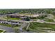 Wide aerial view of school parking lot and buildings with neighboring suburb and bright blue sky at 12604 Madison Way, Thornton, CO 80241
