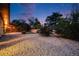 Spacious backyard with gravel, lawn, trees, and a covered patio at dusk at 7382 E Bates Dr, Denver, CO 80231